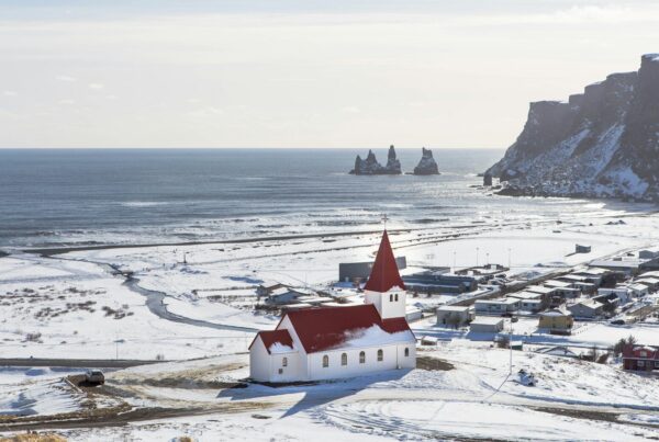 Photographie aérienne d'une maison en béton blanc et rouge près du village