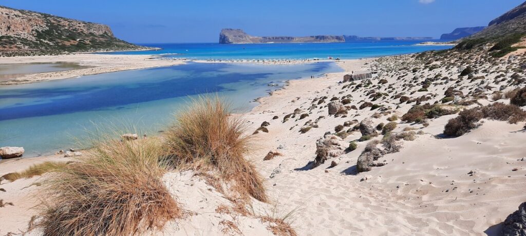 uma praia de areia com um corpo d'água ao fundo