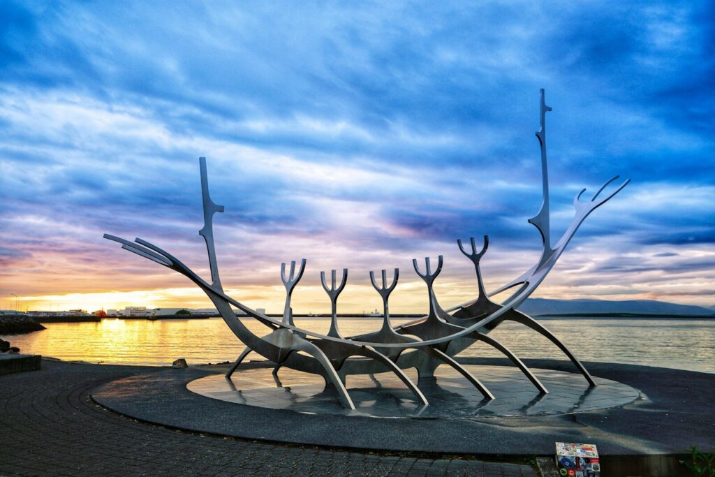 Uma grande escultura de metal situada ao lado de um corpo d'água