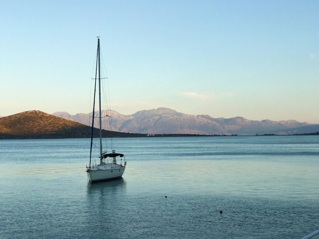 Barco branco navegando sob céu azul durante o dia