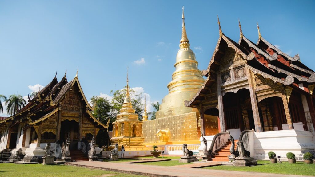 a row of gold and white pagodas in a park