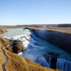 Majestic waterfall cascading into a canyon under a clear sky