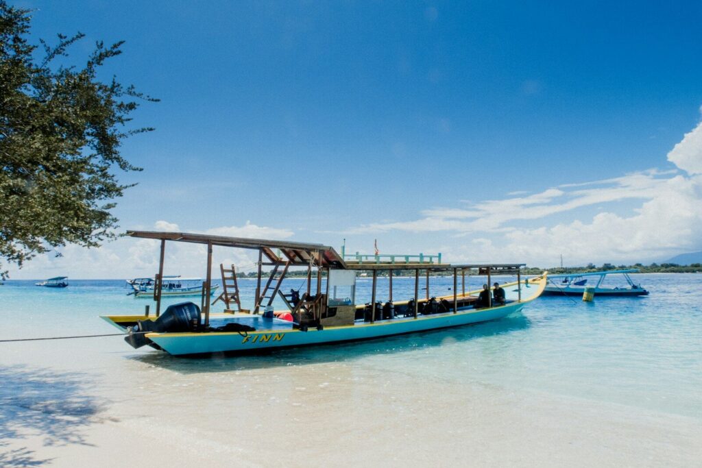Barco azul e branco na areia branca durante o dia