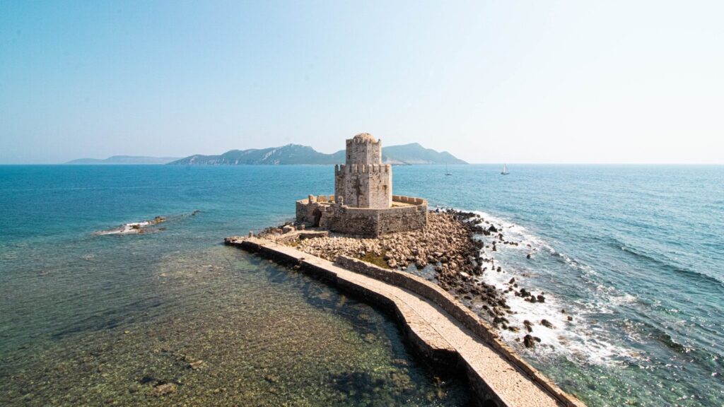 castelo na ilha com ponte durante o dia