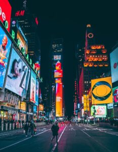 a busy city street at night with neon signs