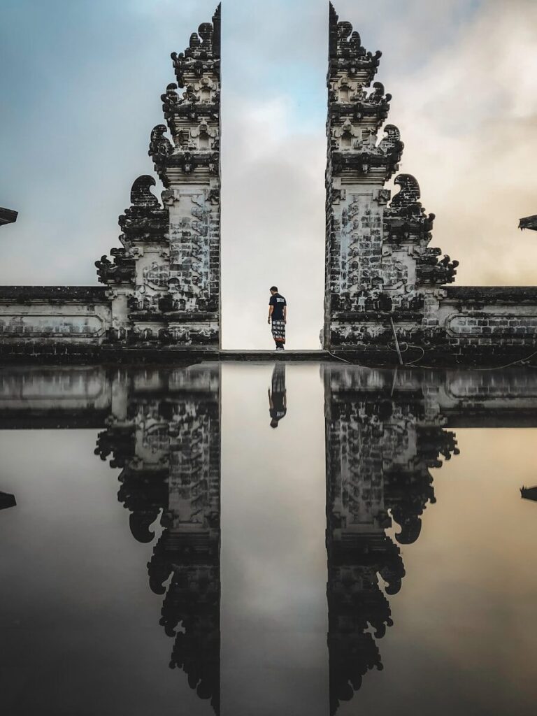 Homem em pé entre ruínas em fotografia com reflexo
