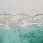bird's eye photography of person standing on coastline