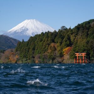 Mount Fuji seen across Lake Ashi in Hakone, with a red torii gate at the shoreline