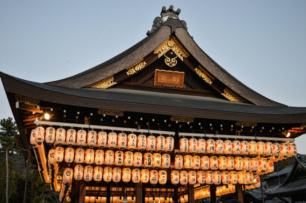 Glowing lanterns lighting up a temple pavilion in Kyoto at dusk