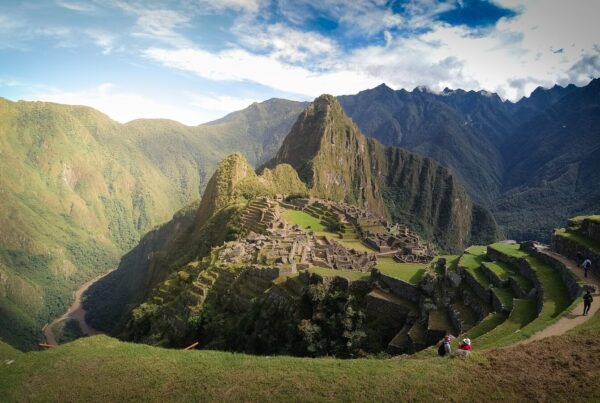 Sunrise light over the terraced ruins of Machu Picchu with green mountains behind