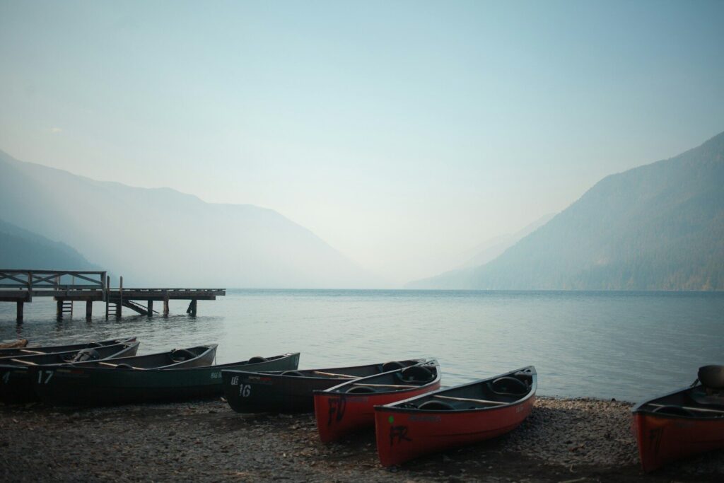Canoes lined along a lake shore at dawn