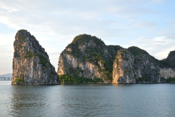 Scenic view of iconic limestone cliffs reflecting in the ocean at Halong Bay, Vietnam.