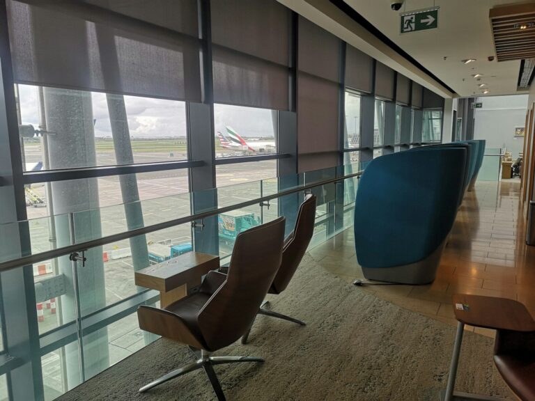 An armchair by a lounge window overlooking the tarmac