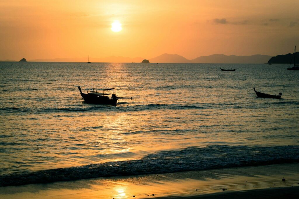 Sunset over the Gulf of Thailand with a boat silhouetted on the water