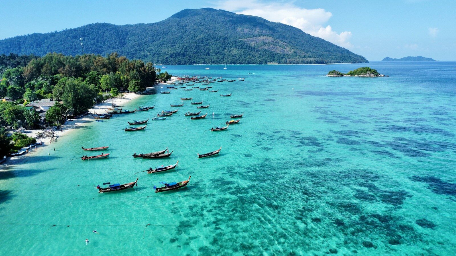 Boats floating on clear turquoise water seen from above near Koh Lipe, Thailand
