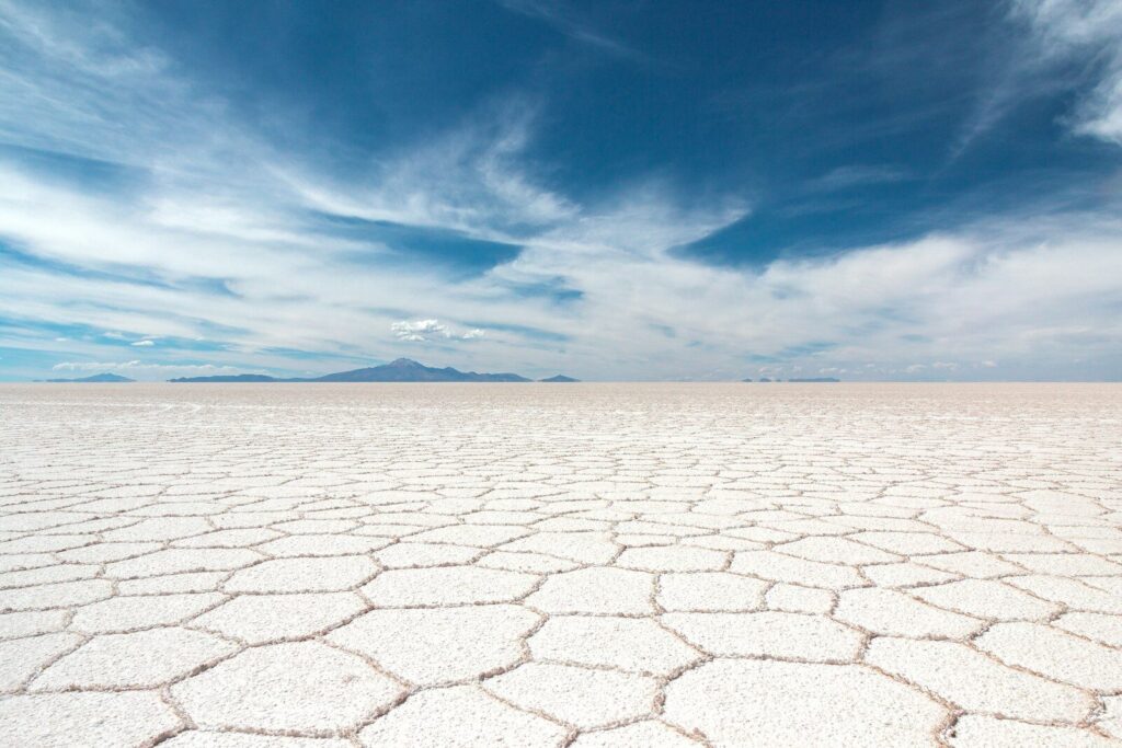Cracked white salt hexagons stretching to the horizon on the Salar de Uyuni in the dry season