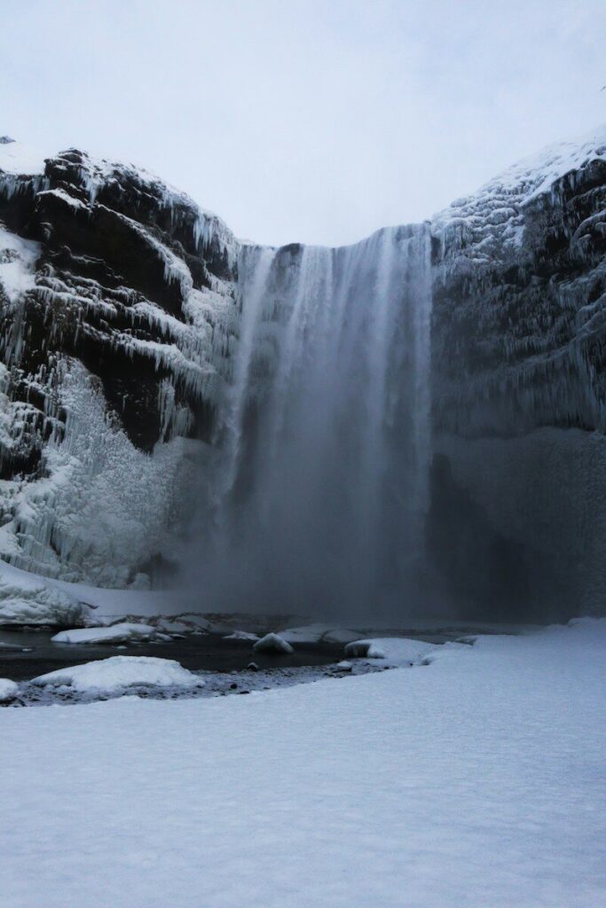 Skógafoss waterfall framed by snow and ice in winter